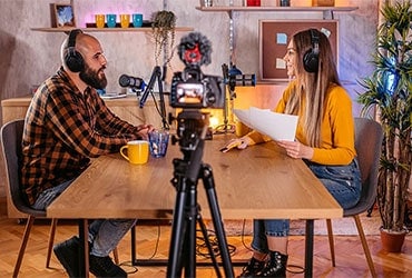 Business owner sitting at table participating in podcast