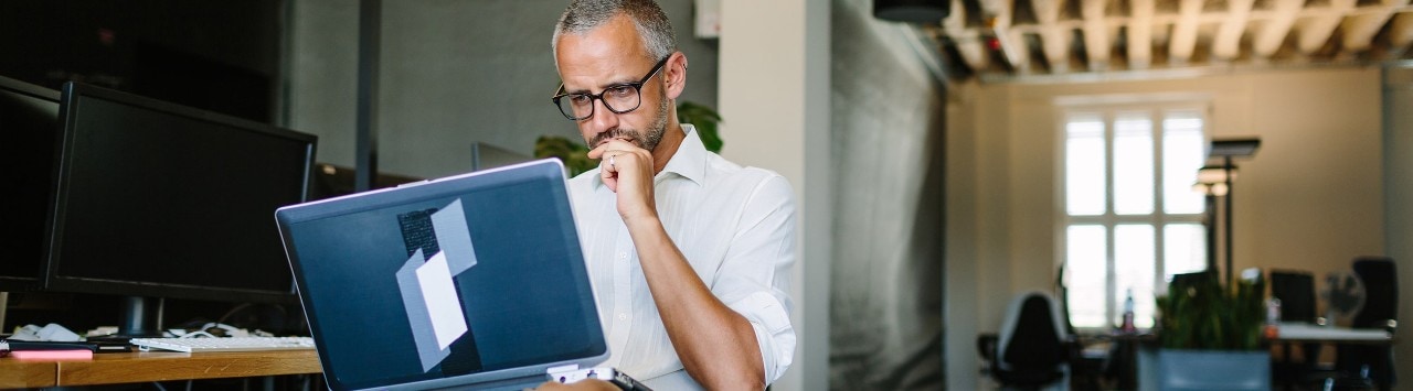 Business owner reviewing competitor’s website on laptop