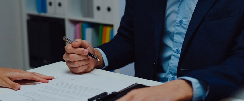 Two people reviewing and signing financial paperwork