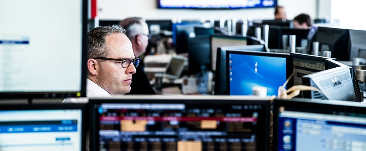 Room full of financial analysts with computer monitors in the foreground