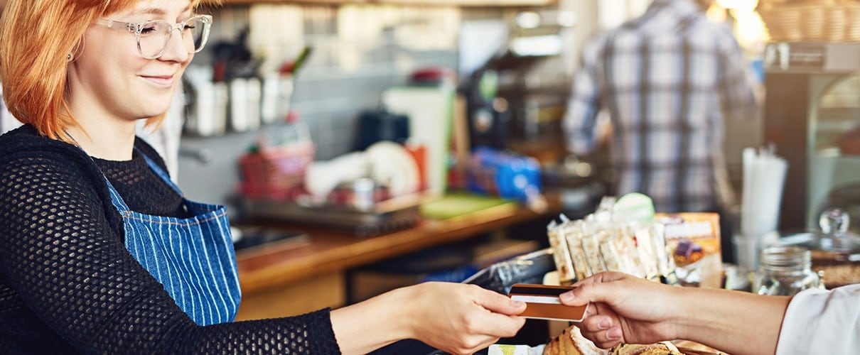 Girl accepting credit card payment in cafe