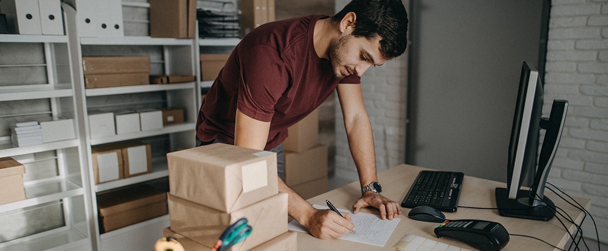 Delivery person preparing bar codes for packages, checking to do list