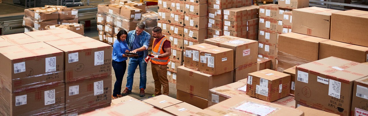 people at work in a large warehouse full of boxes