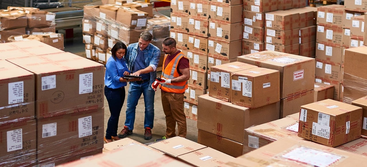 people at work in a large warehouse full of boxes