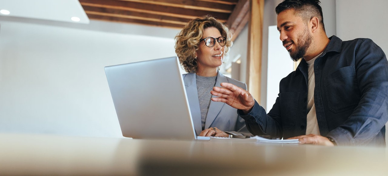 Two business colleagues reviewing information on a laptop