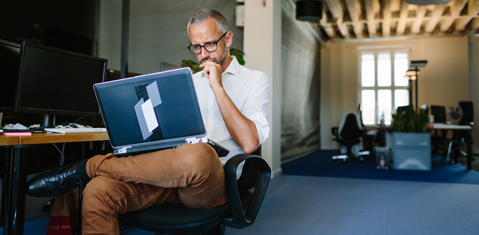 Business owner reviewing competitor’s website on laptop