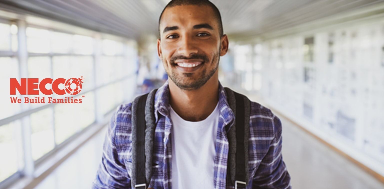 Young Hispanic man holding backpack, with Necco logo