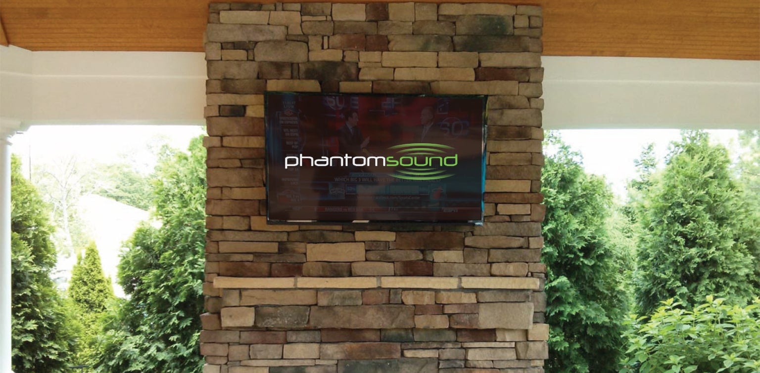 Television hung on a stone mantle displaying Phantom Sound logo