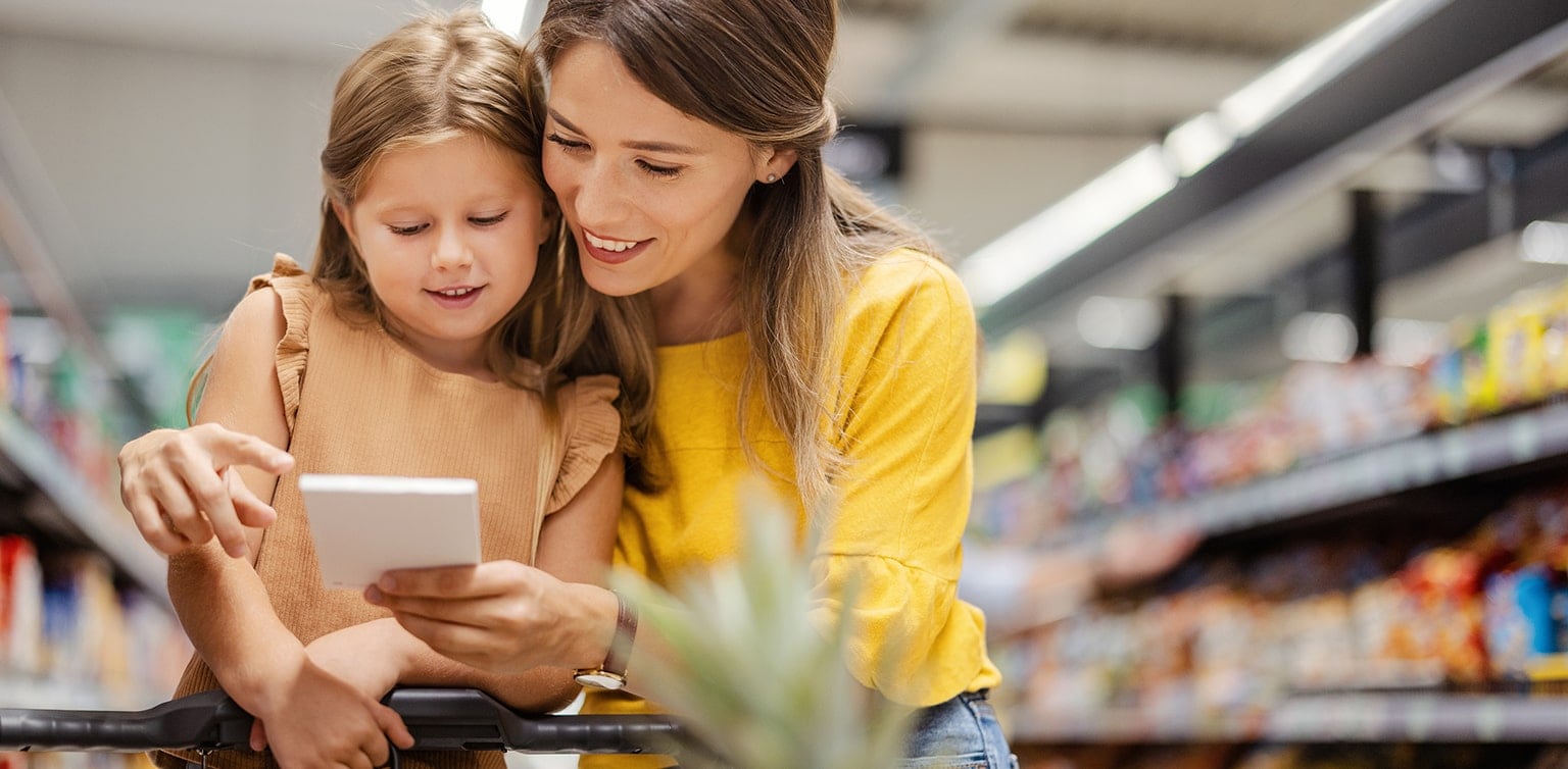 Mother and daughter in grocery store looking at shopping list