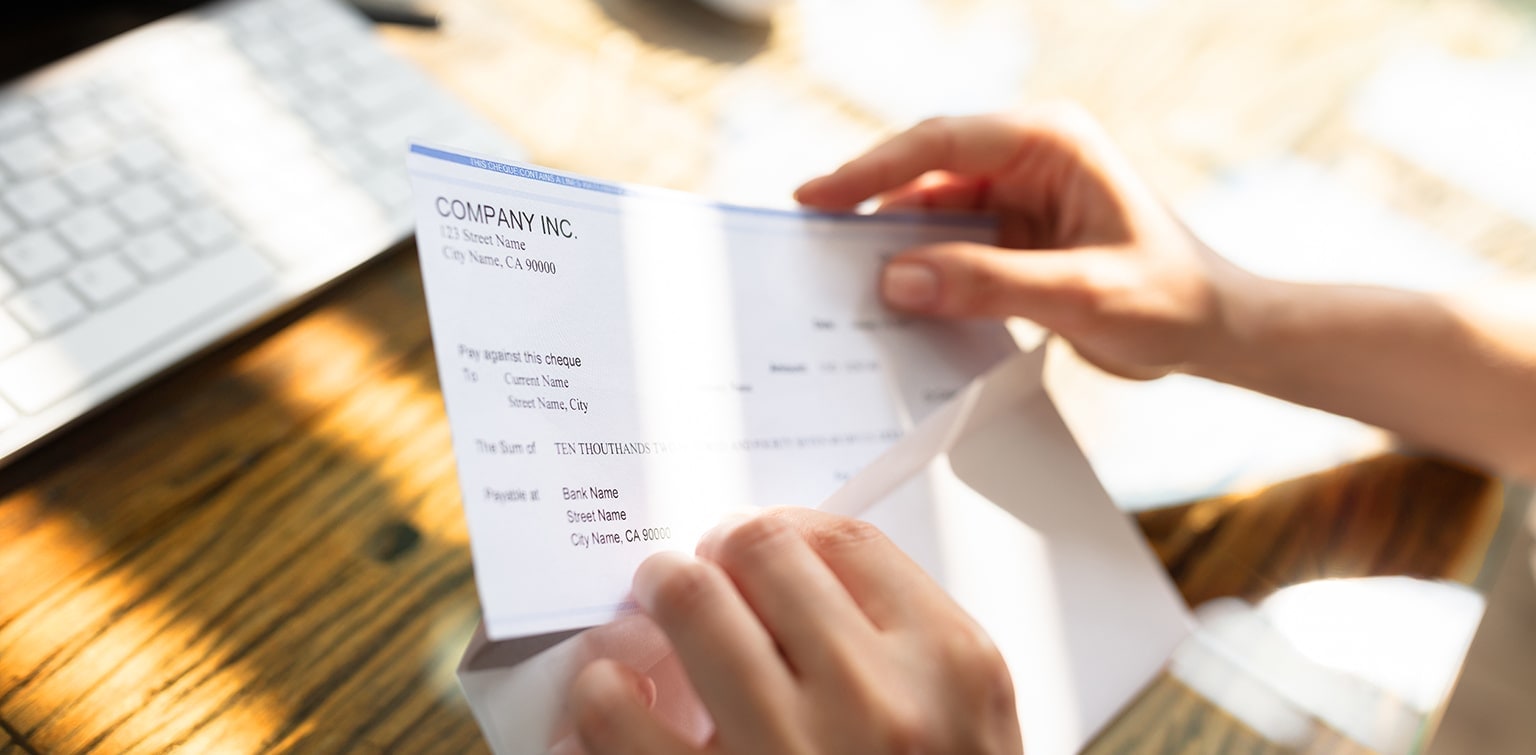 Businessperson removing accounts receivable check from envelope