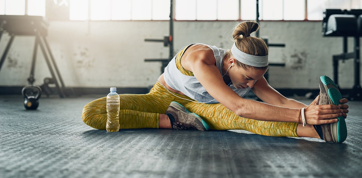 Woman stretching in gym before workout