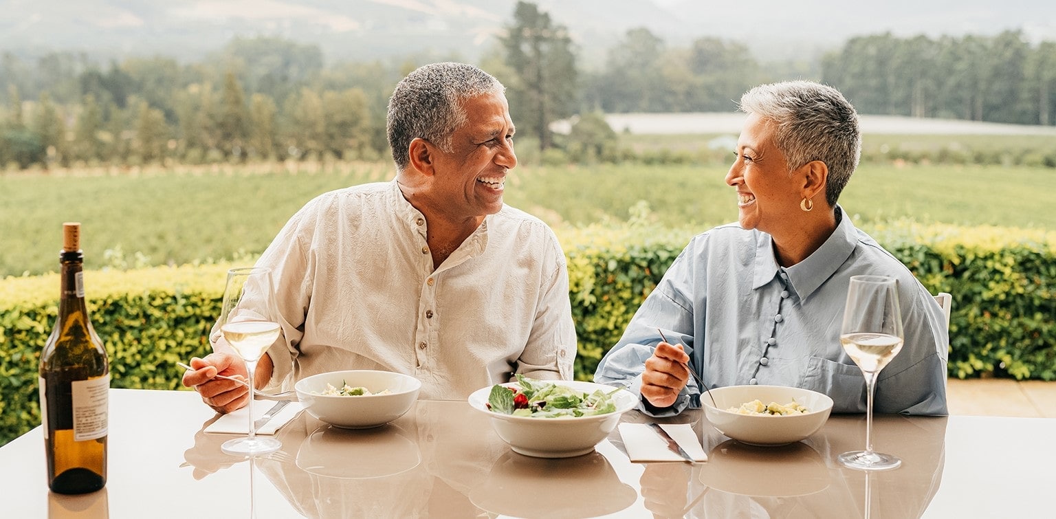 Smiling senior couple eating dinner outdoors