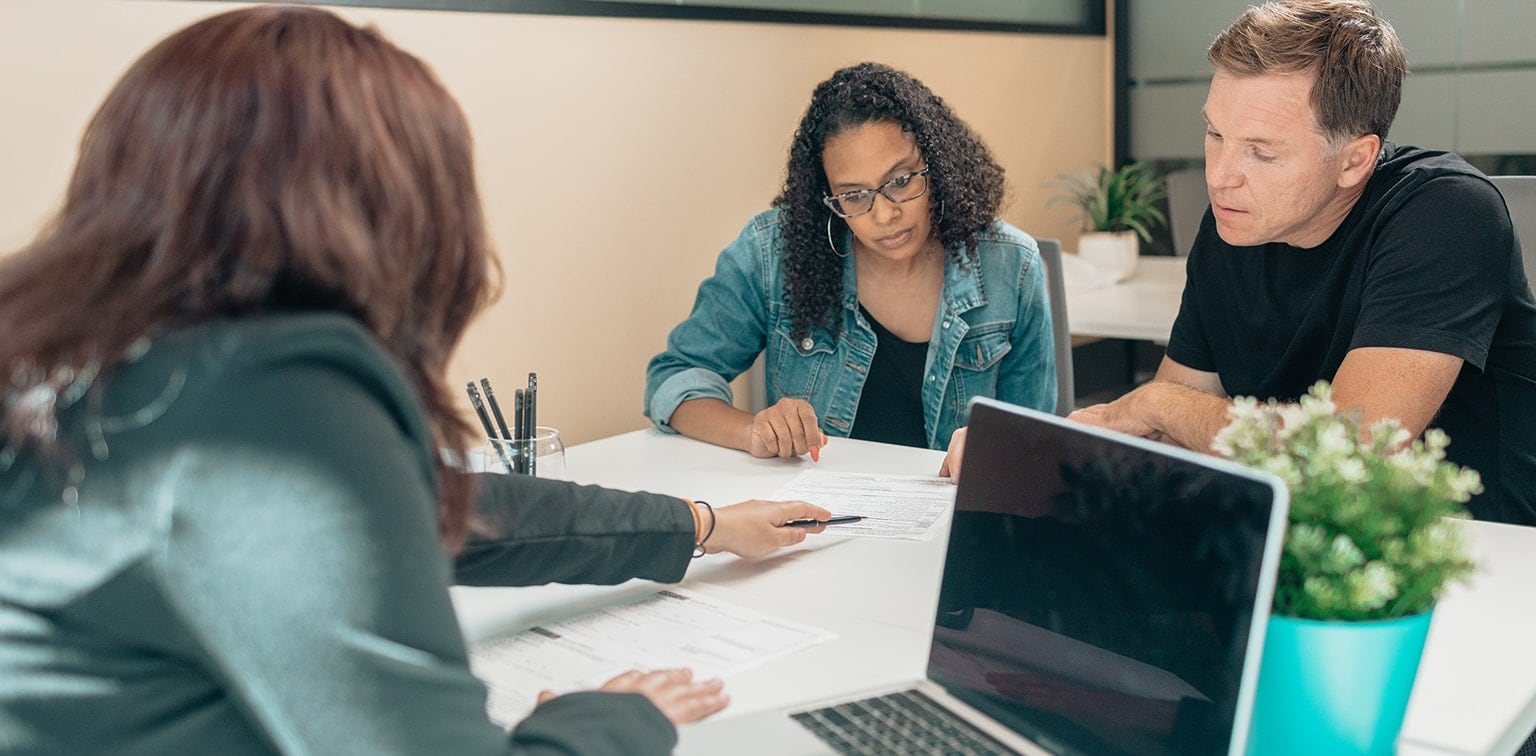 A couple reviews the portfolio construction of their investments with a financial planner as part of their wealth goal-setting process