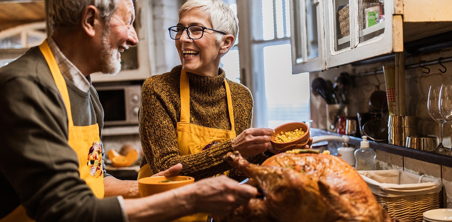 Older Caucasian couple preparing Thanksgiving dinner