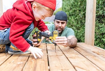 Man and child using power tools