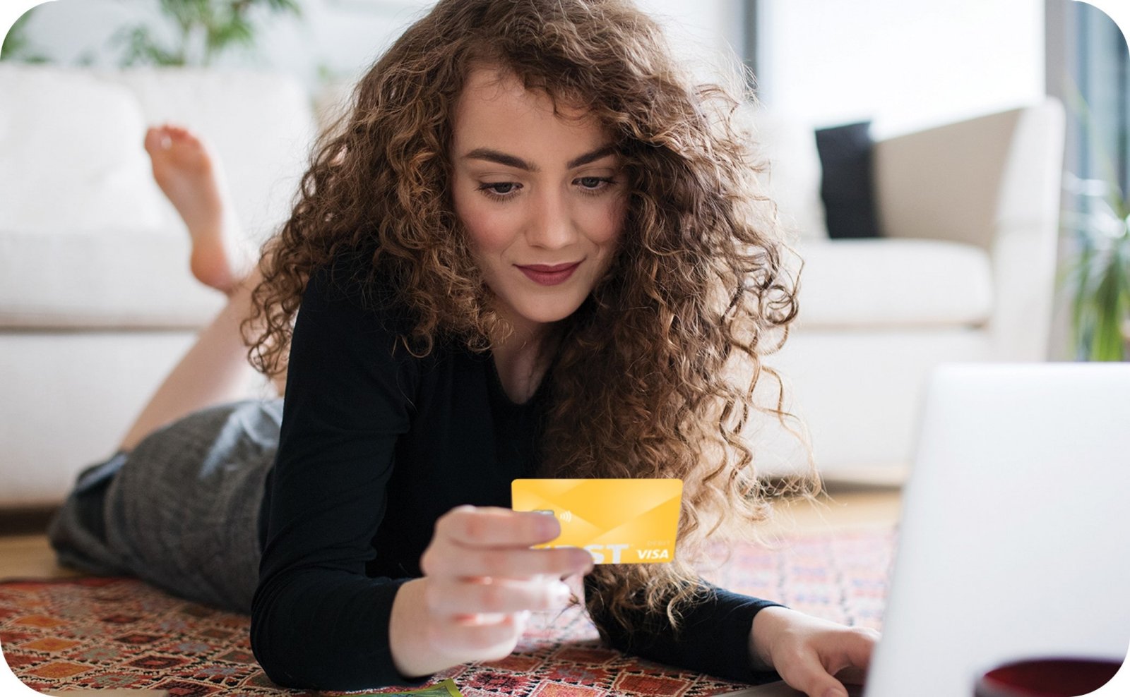 Young Caucasian woman on laptop using First Financial debit card