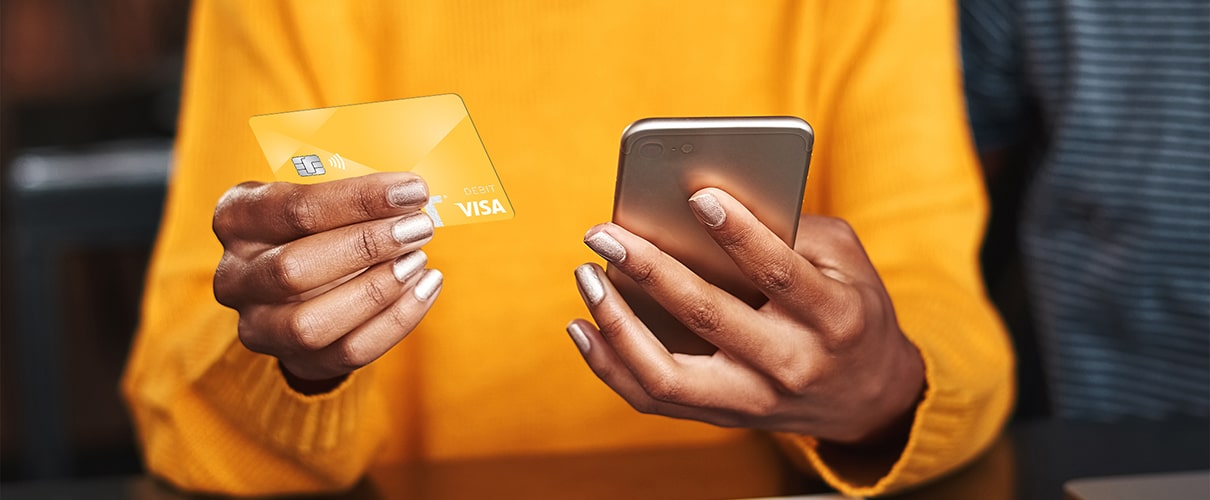 Woman using First Financial Bank debit card to make purchase on smartphone