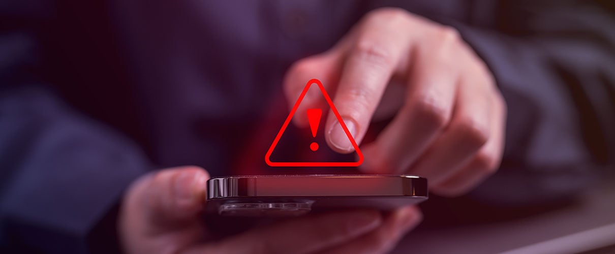 man on his phone with a red exclamation mark above it