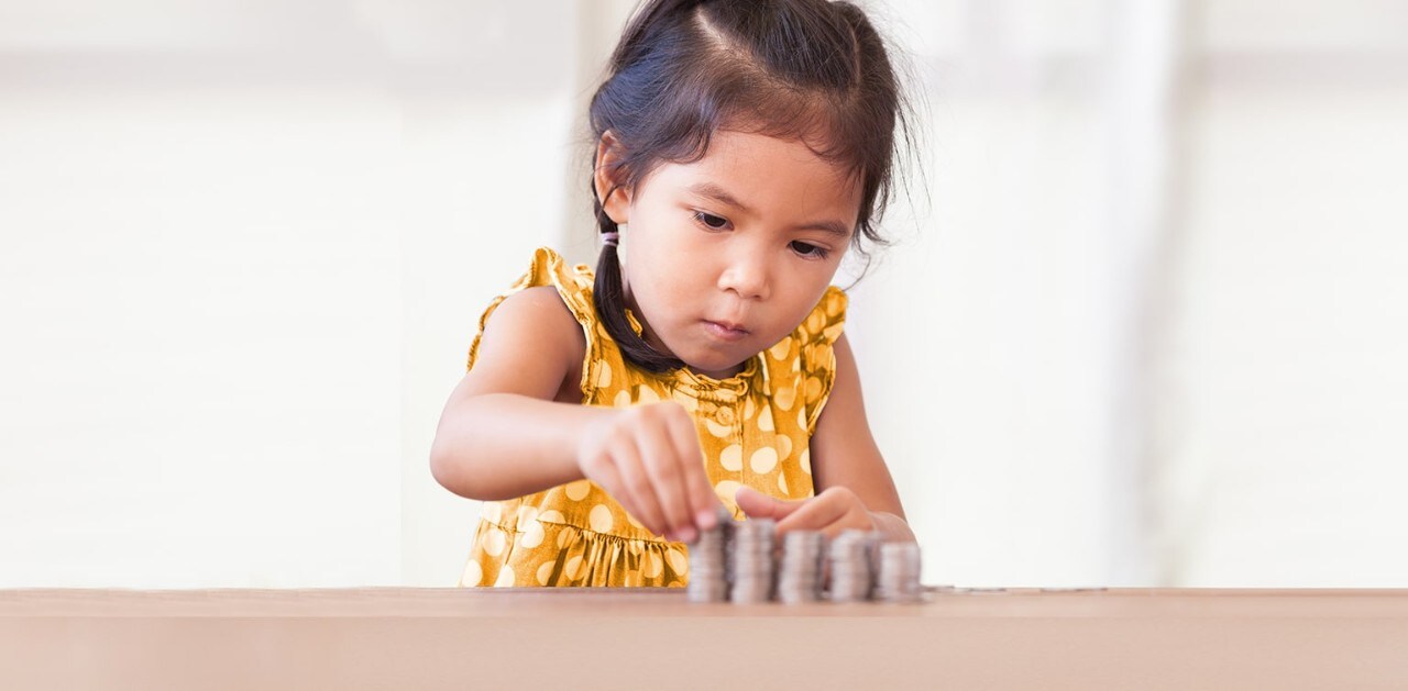 Young Asian girl stacking coins