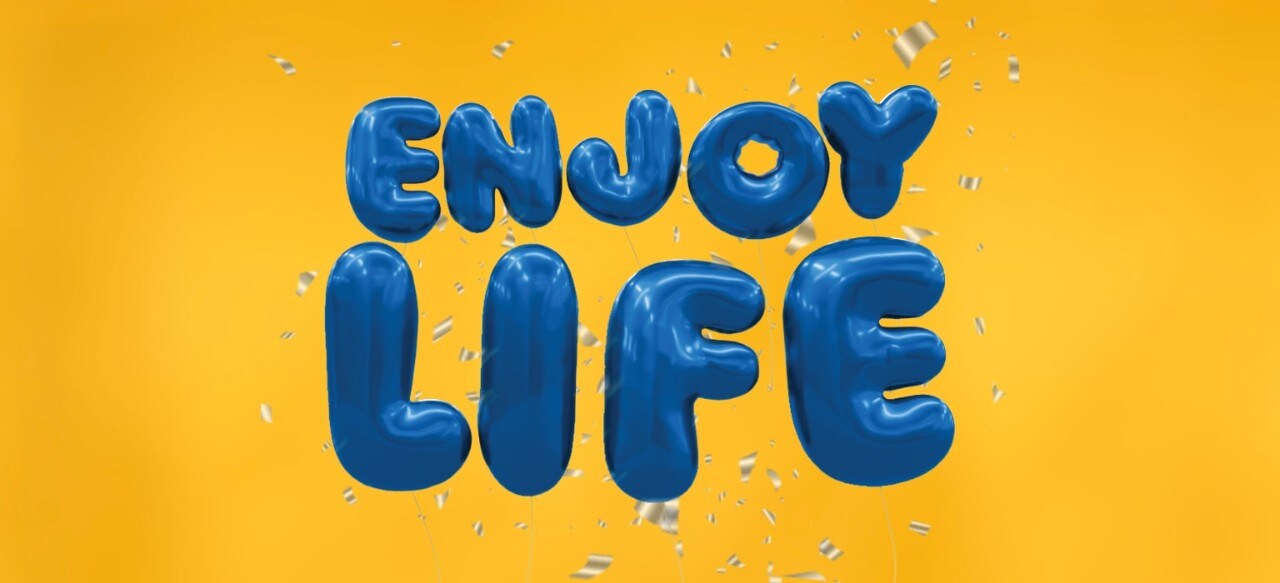 "Enjoy life" spelled out in blue balloons on a gold background