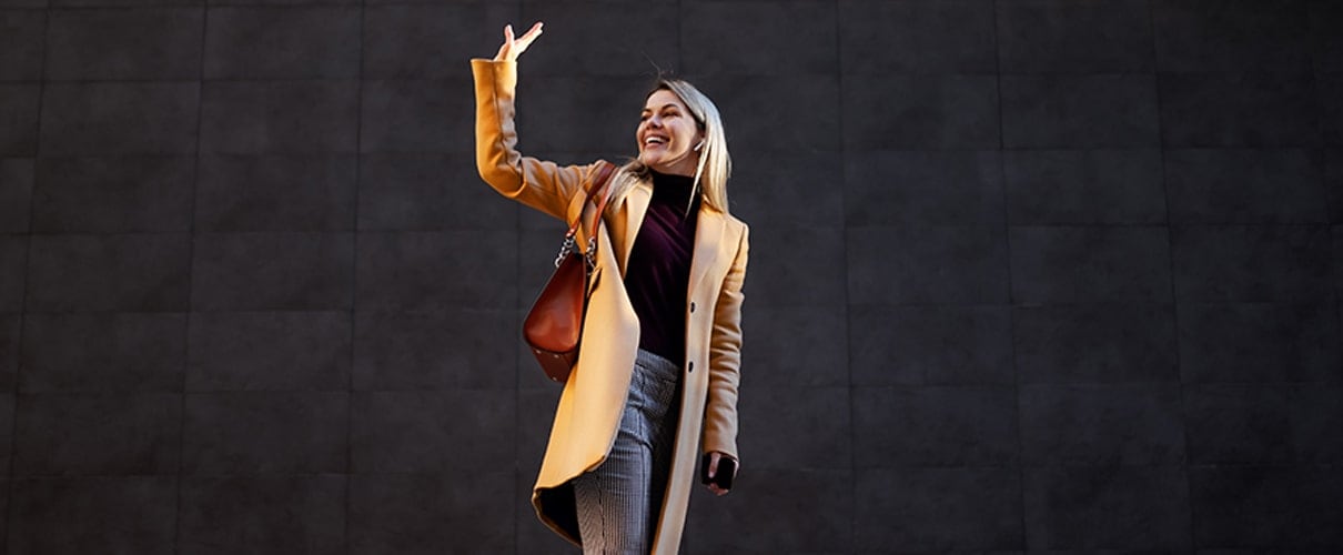 Woman walking away waving goodbye