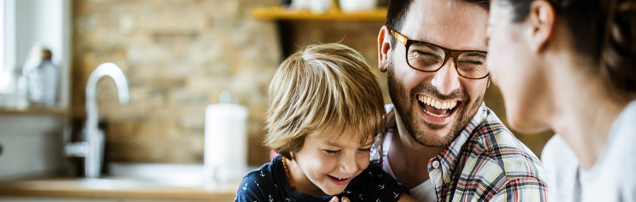 Smiling mother, father, and son in kitchen