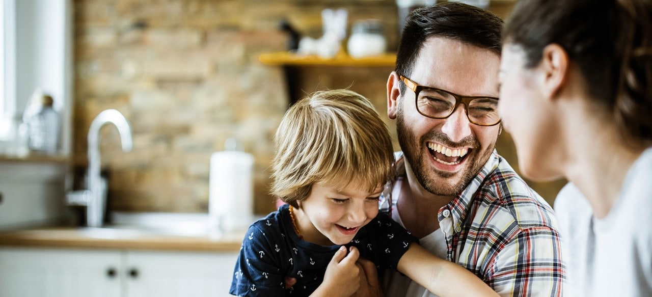 Smiling mother, father, and son in kitchen
