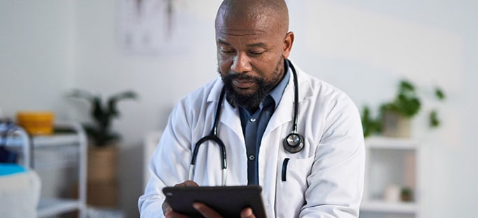 African-American physician reviewing information on a tablet