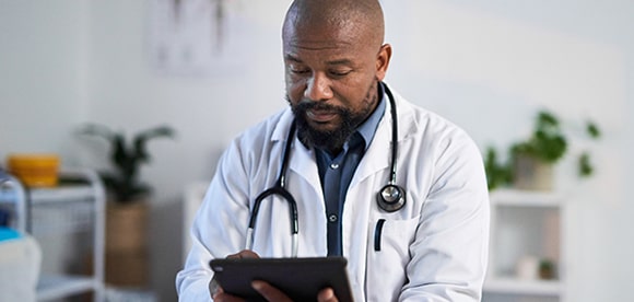 African-American physician reviewing information on a tablet