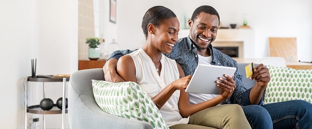 African-American couple making credit card purchase using tablet