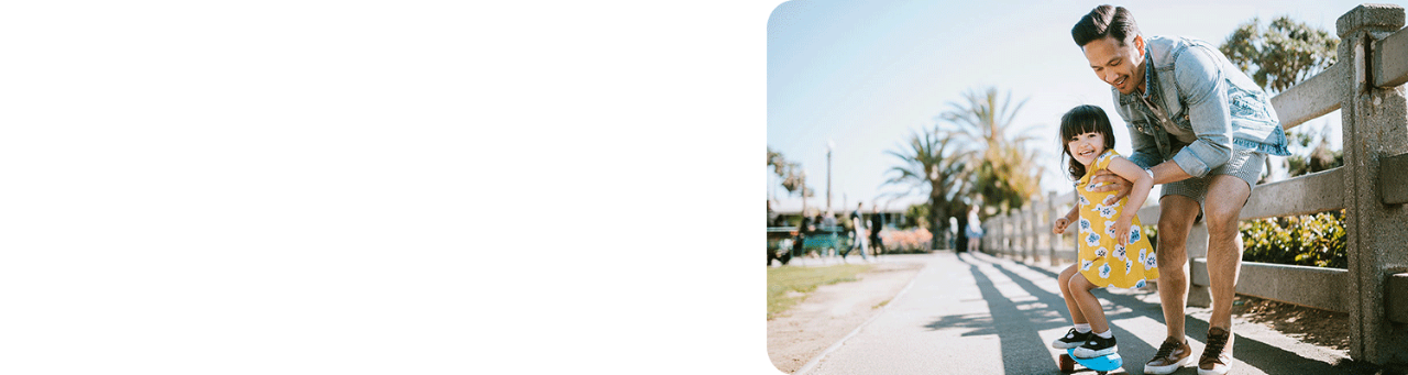 Father helping his young daughter ride a skateboard