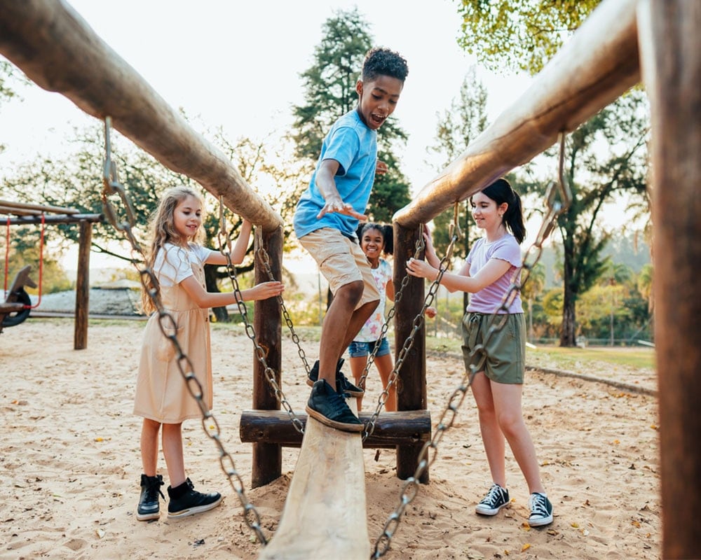 Four children playing on playground equipment