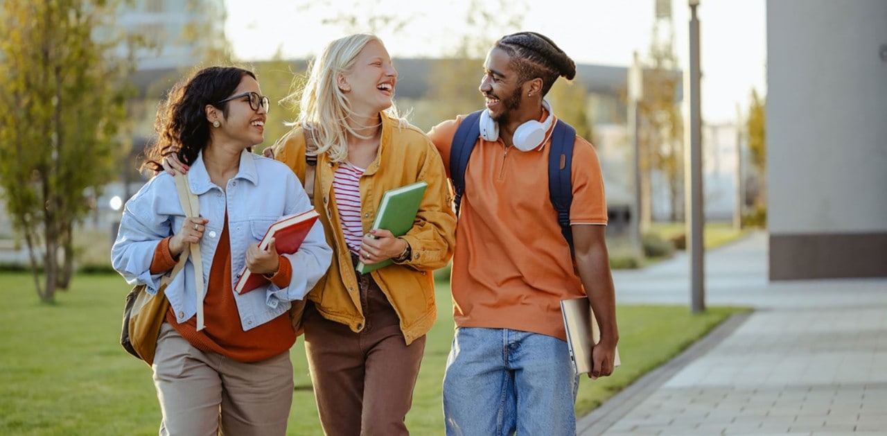Three diverse college students walking and chatting
