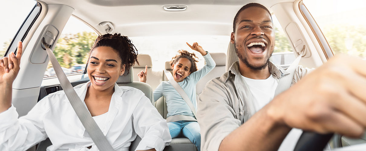 Happy African-American family driving new car