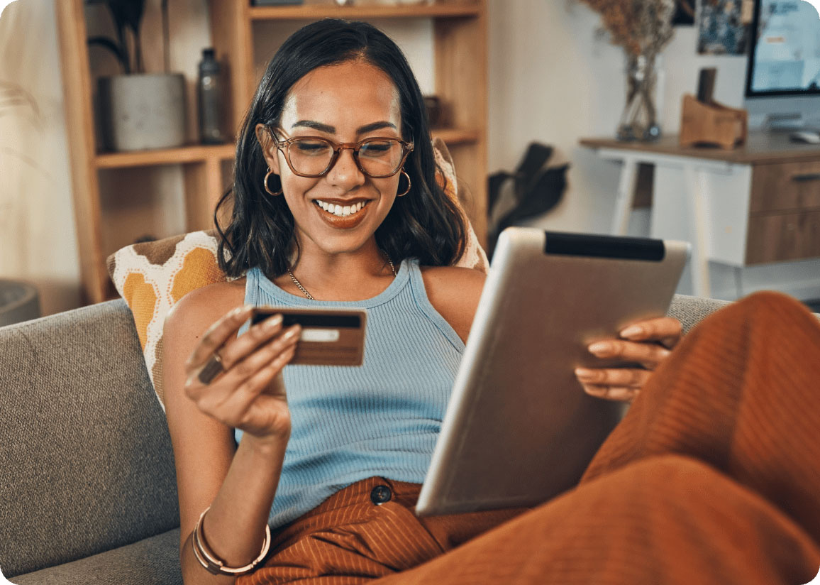 Smiling African-American woman making credit card purchase using tablet