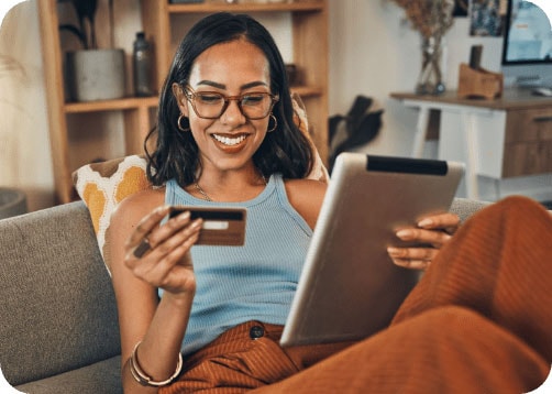 Smiling African-American woman making credit card purchase using tablet