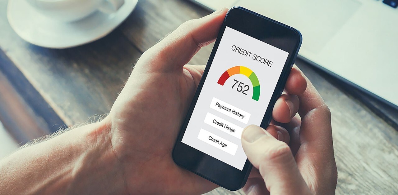 Man holding smartphone showing credit score