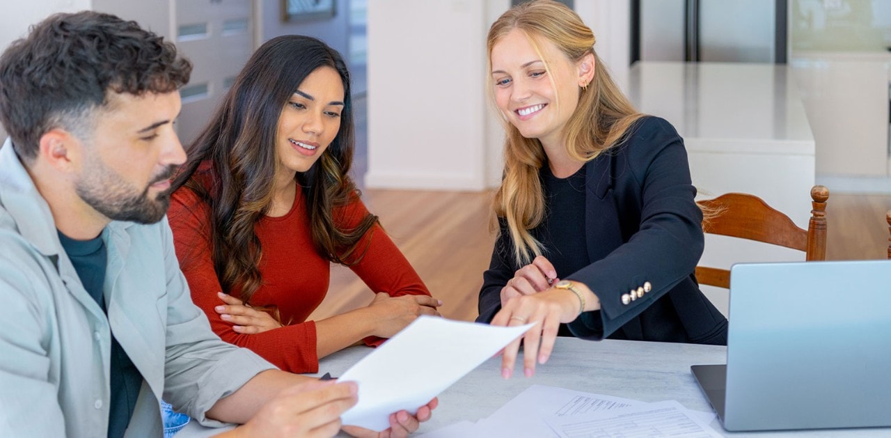 Couple reviewing financial documents with female banker