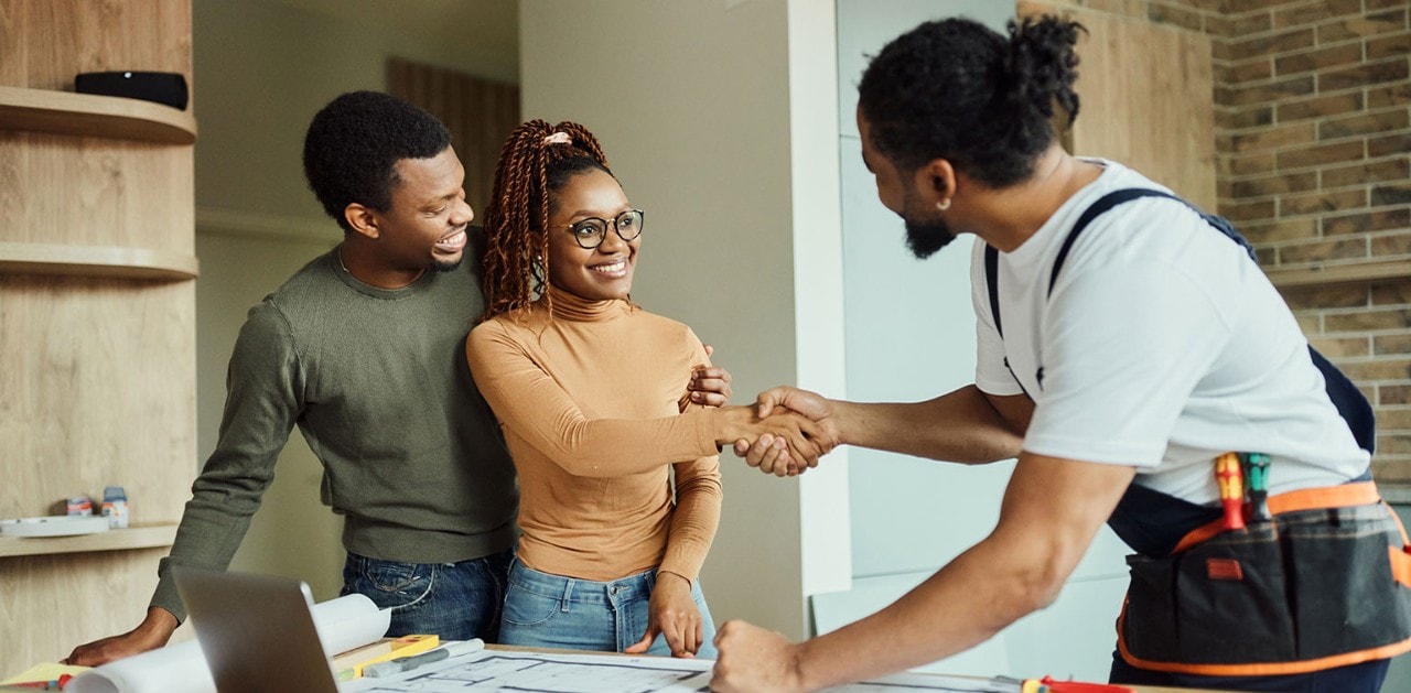 Smiling African-American couple shaking hands with contractor