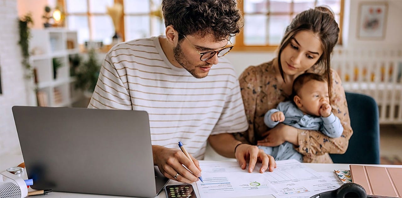 A man doing finances at a table with his family