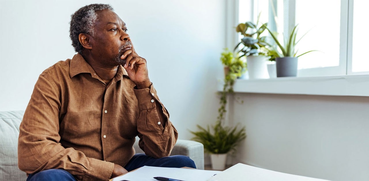 Mature African-American man looking thoughtfully out of window