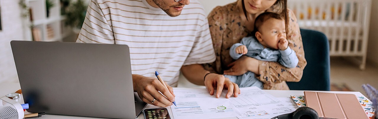 A man doing finances at a table with his family