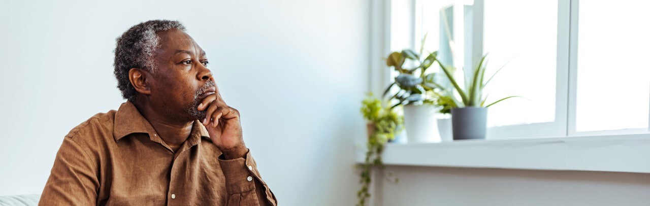 Mature African-American man looking thoughtfully out of window