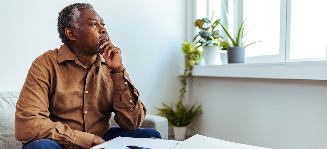 Mature African-American man looking thoughtfully out of window