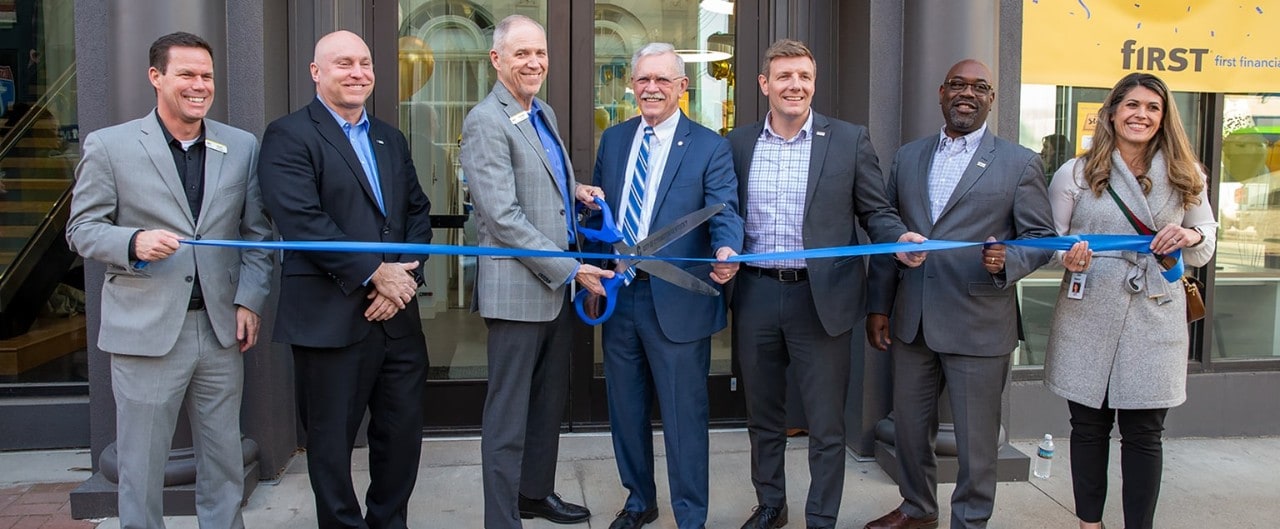 Group of people cutting a ribbon