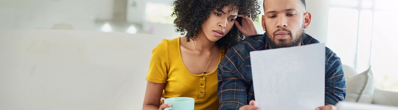 Concerned African-American couple reviewing financial document