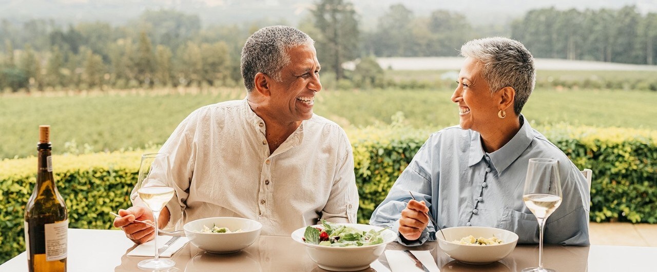 Smiling senior couple eating dinner outdoors