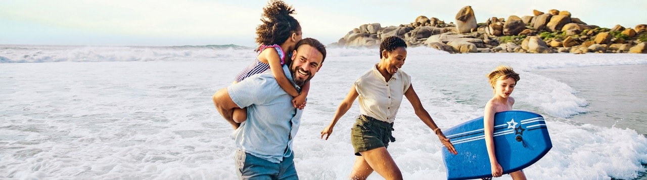 Happy family playing in the surf at the beach