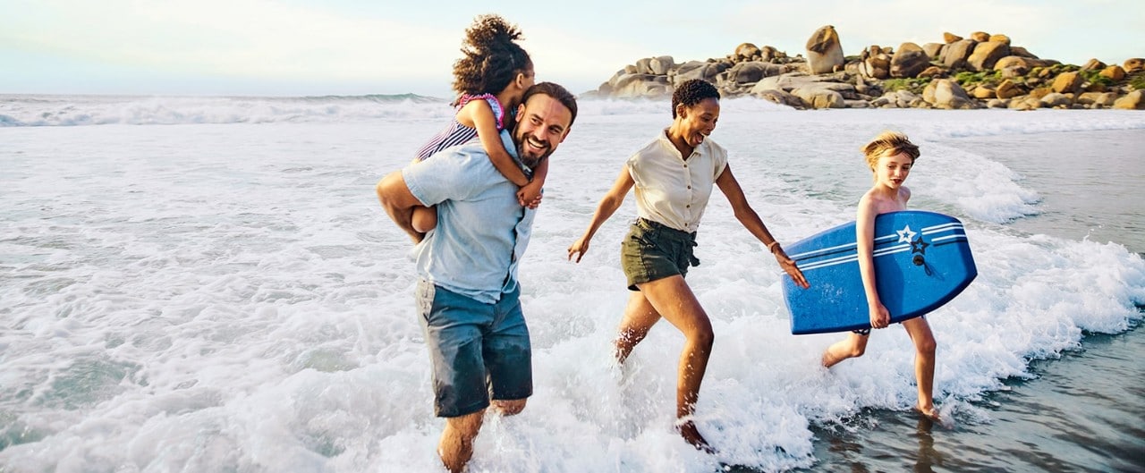 Happy family playing in the surf at the beach