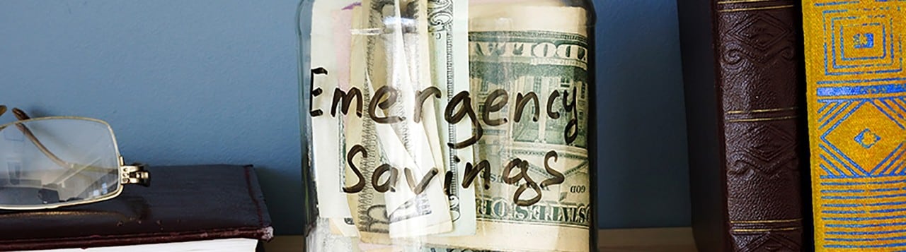 Jar on bookshelf with emergency savings cash